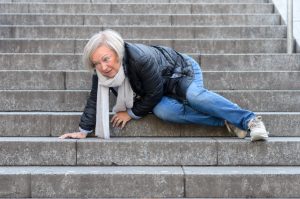 Senior woman accidentaly falling down stone steps outdoors