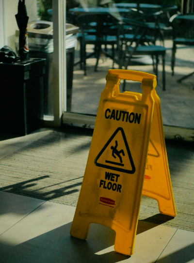 A "Caution: Wet Floor" sign on business premises.