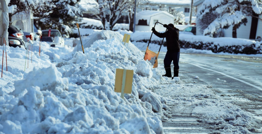 A responsible property owner clearing snow from sidewalk.